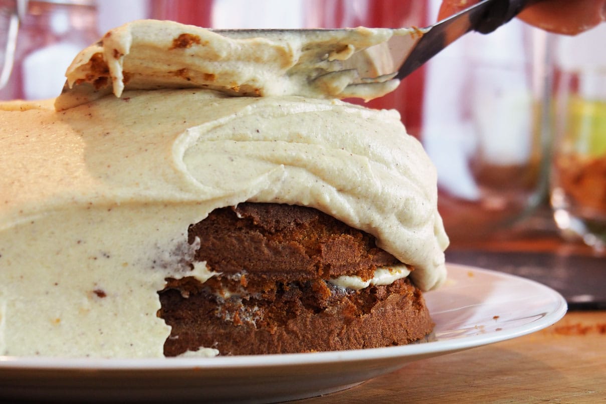 putting the frosting on the pumpkin cake
