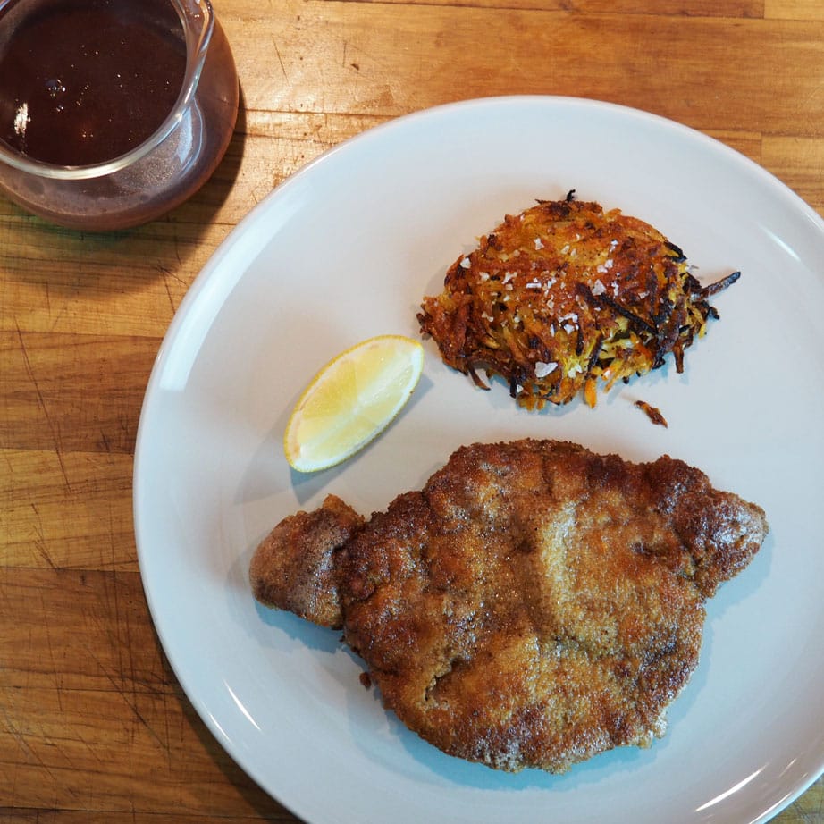 typical austrian dish, schnitzel with rösti and a quarter of lemon