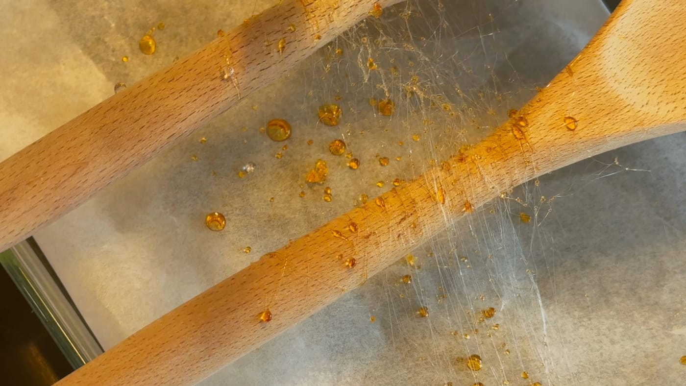 Caramel threads spun over two wooden spoons